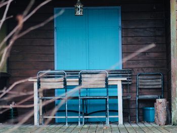 Empty chairs against wall of old building