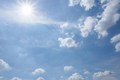 Low angle view of sunlight streaming through clouds