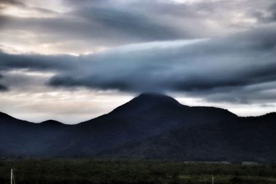 Scenic view of mountains against cloudy sky