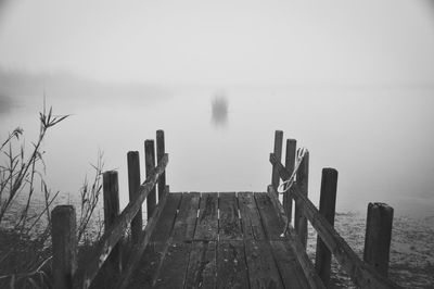 Wooden pier over sea against sky