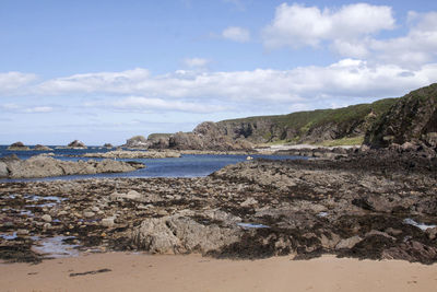 Scenic view of mountain at sea shore against sky