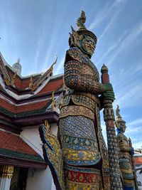 Low angle view of statues on building against sky