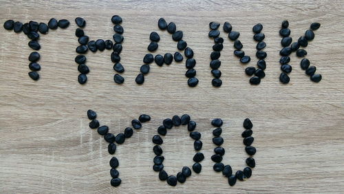 High angle view of thank you text made with seeds on table