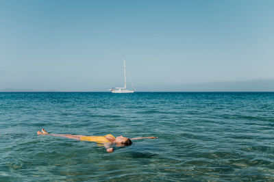 Man diving in sea against clear sky