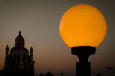 Low angle view of illuminated building against sky during sunset