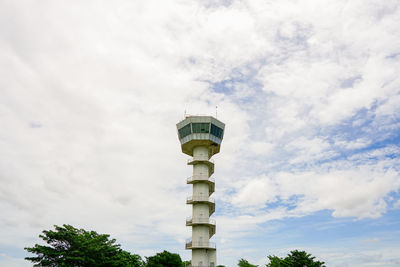 Low angle view of communications tower against cloudy sky