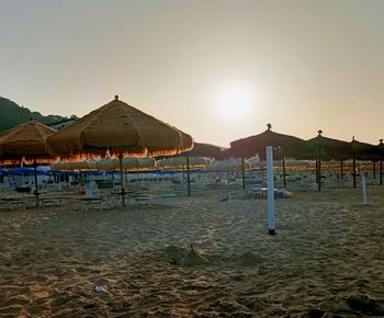 Scenic view of beach against clear sky during sunset