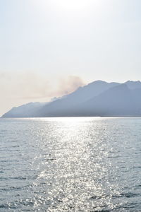 Scenic view of sea and mountains against sky