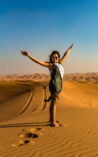 Full length of woman standing on sand dune