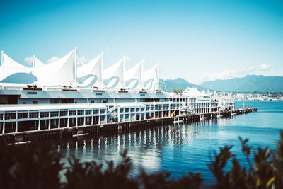 Sailboats moored in sea against sky