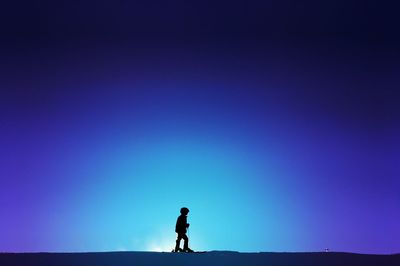 Rear view of silhouette man standing against clear sky