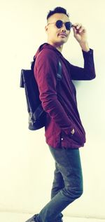 Young man wearing sunglasses standing against camera