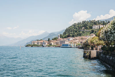 Scenic view of sea by buildings against sky