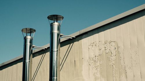 Low angle view of pipes against clear sky