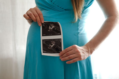 Midsection of woman holding heart shape