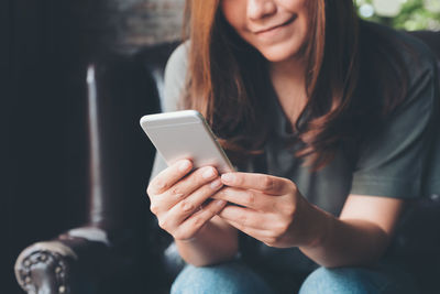 Midsection of woman using mobile phone