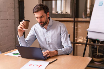 Young man using laptop at table