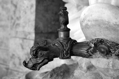 Close-up of dragon shaped faucet on wall