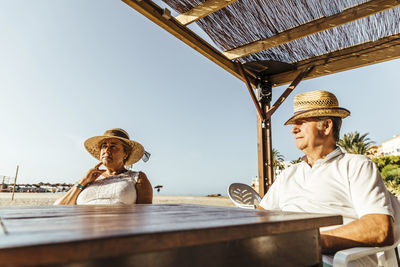 Senior couple sitting at a bar terrace at the beach, el roc de sant gaieta, spain