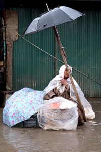 Woman lying on wet bed in rain