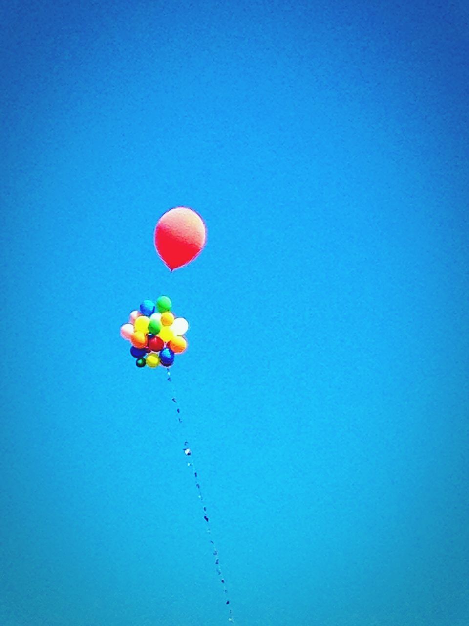 clear sky, blue, copy space, low angle view, balloon, mid-air, multi colored, flying, hot air balloon, nature, outdoors, beauty in nature, no people, sky, colorful, day, yellow, parachute, sunlight, red