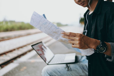 Midsection of man holding paper