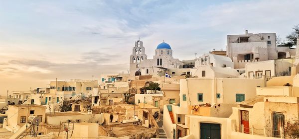 Buildings in city against sky during sunset