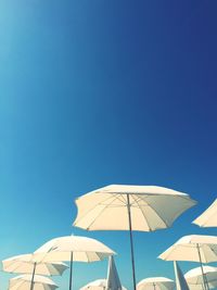 Low angle view of parasol against blue sky