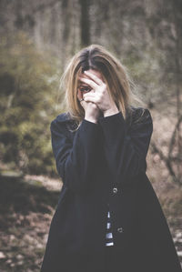 Beautiful young woman standing in a forest