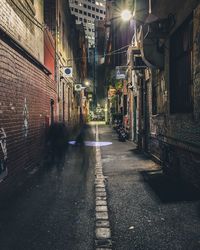 Street amidst buildings in city at night