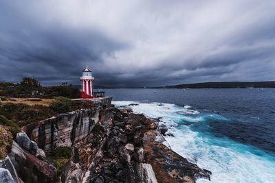 Lighthouse by sea against sky