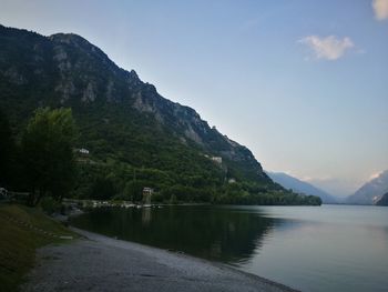 Scenic view of river by mountains against sky