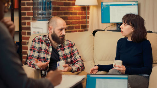 Portrait of woman using phone while sitting in office