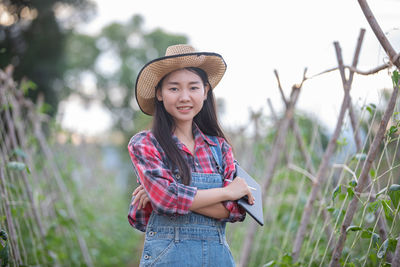 Portrait of a smiling young woman standing on field