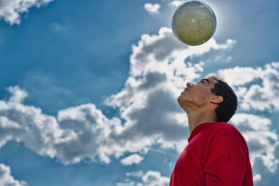 Low angle view of man standing on soccer field against sky