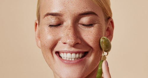 Close-up portrait of young woman against white background