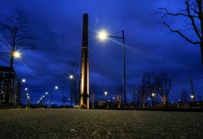 Low angle view of illuminated street lights at night