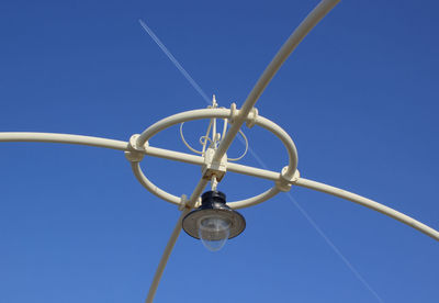 Low angle view of lighting equipment against blue sky