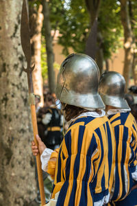 Side view of men on warrior costumes standing forest 