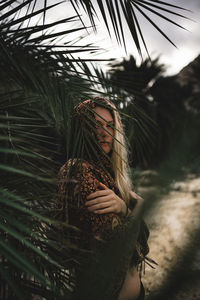 Portrait of young woman with tree