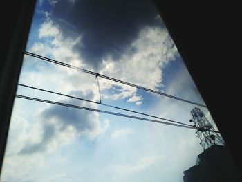 Low angle view of power lines against cloudy sky