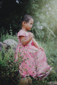 Cute girl with pink flowers on field