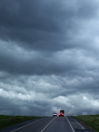 Car on highway against cloudy sky