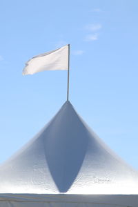 Low angle view of flag against blue sky