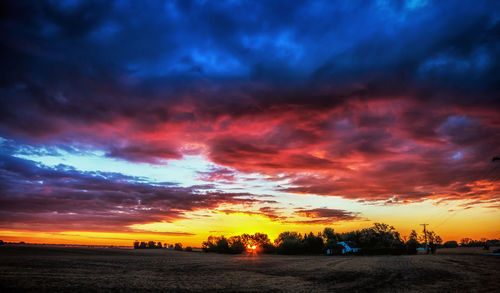 Scenic view of dramatic sky over silhouette landscape