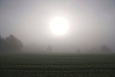 Scenic view of field against sky during foggy weather