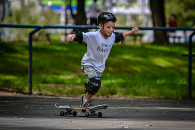 Full length of boy skateboarding on road 