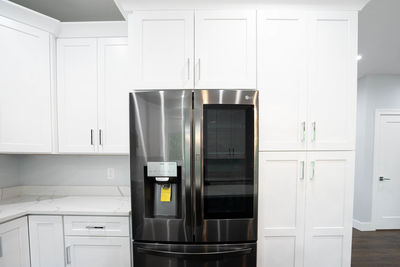 Remodeled kitchen has white cabinets installed and modern appliances