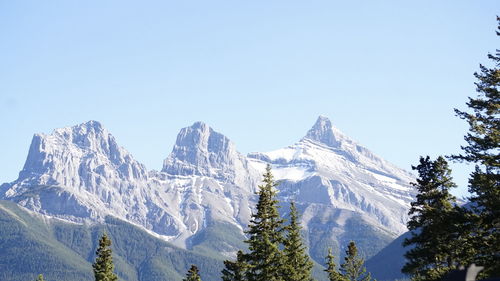 Scenic view of snow covered mountains against clear blue sky