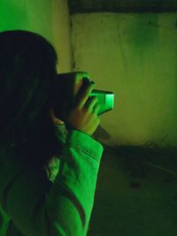 Close-up of man photographing illuminated smart phone